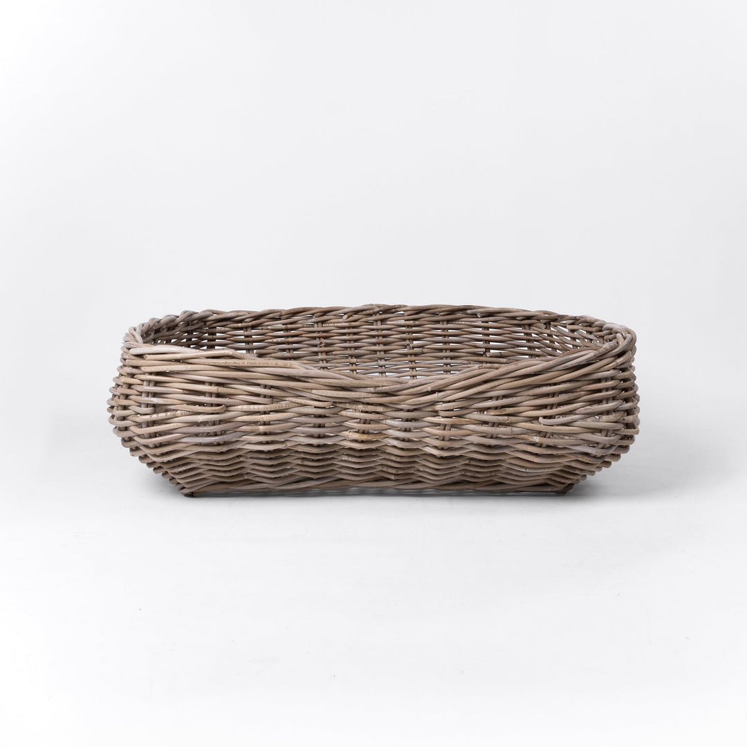 A classic wicker dog basket - a grewash rattan dog basket - woven with natural rattan canes, on a white background, viewed from the front.
