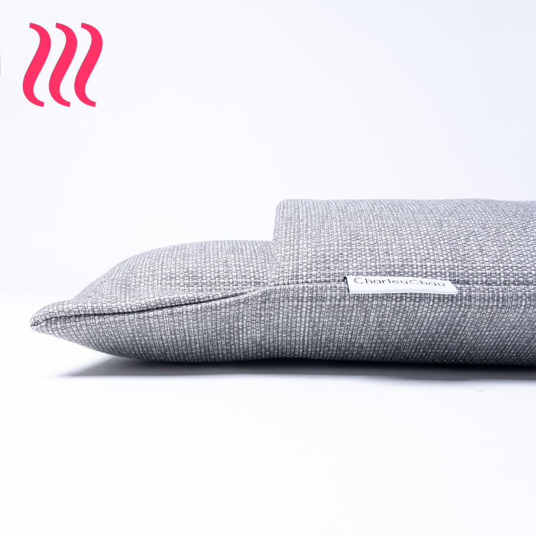 Close up detail in side profile of the front of a luxury sleeping bag style dog burrow bag by Charley Chau in a grey woven upholstery fabric on a white background wit hte Charley Chau brand label visible.