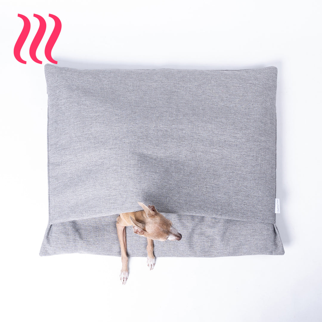Italian Greyhound dog peeking out of a luxury sleeping bag style dog burrow bag by Charley Chau in a grey woven upholstery fabric with the Charley Chau brand label visible, on a white background.