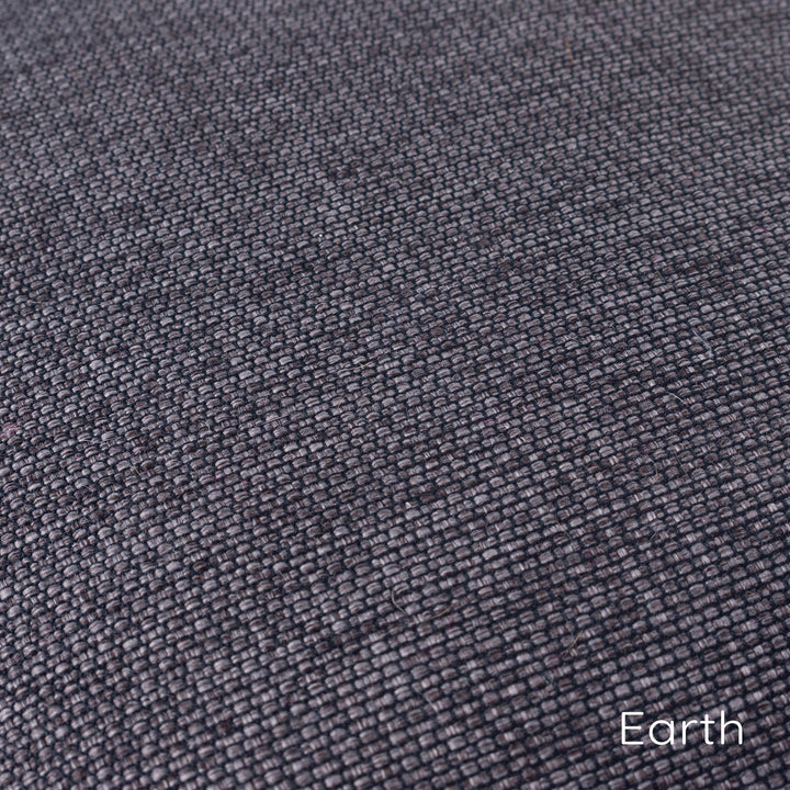 Close up detail of a woven upholstery fabric called Weave II in a dark browny black colour called Earth.