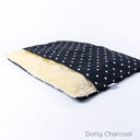 Luxury dog bed with cover, a Charley Chau Dog Burrow Bag, in a charcoal black polka dot print fabric with a cream faux-fur lining.
