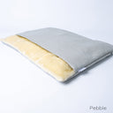 A pale beige colour luxury dog burrow bag, a snuggle bag type of dog bed, by designers Charley Chau, with a pale beige outer cover and cream faux-fur fleece lining on a white backdrop.