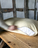 Dog Bed Mattress with a beige waterproof bed liner on it being unzipped, on a wooden table with a rustic background.