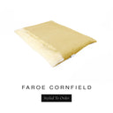 A luxurious Dog Burrow Bag, a sleeping bag style dog bed or snuggle sack style dog bed, with an outer cover in golden yellow woven wool texture upholstery fabric Faroe with a plush, cream faux-fur lining, and a badge with the colour name Cornfield on a white background.