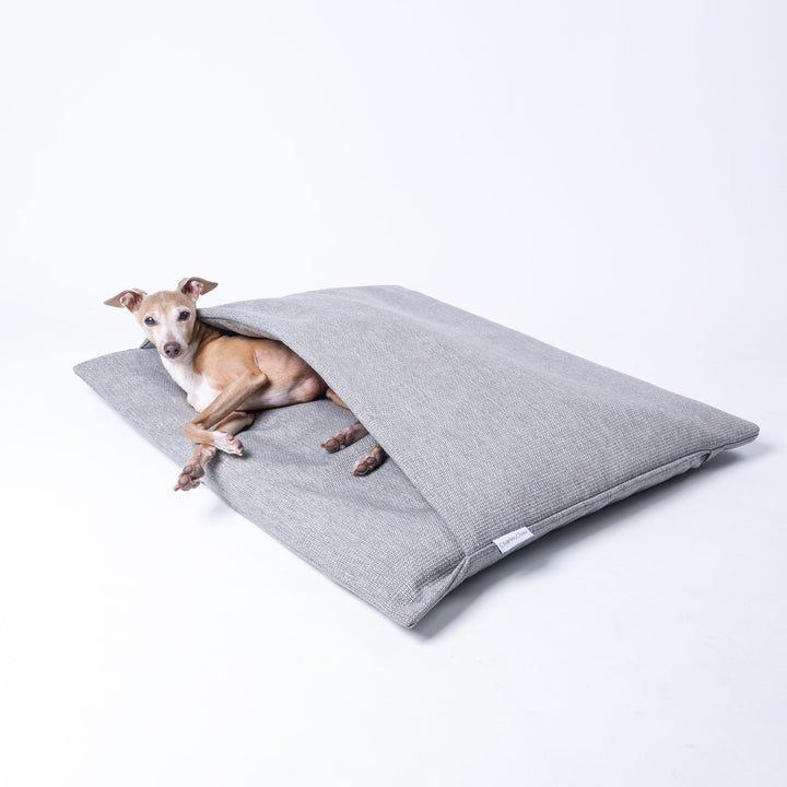 Dog Burrow Bag by designers Charley Chau, a dog sleeping bag style dog bed in Weave II fabric, colour Heron Grey.
