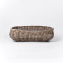 A classic wicker dog basket - a grewash rattan dog basket - woven with natural rattan canes, on a white background, viewed from the front.