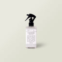 Aromatherapy Dog Bed Refresher Spray in a clear spray bottle with black nozzle on a pale sage background