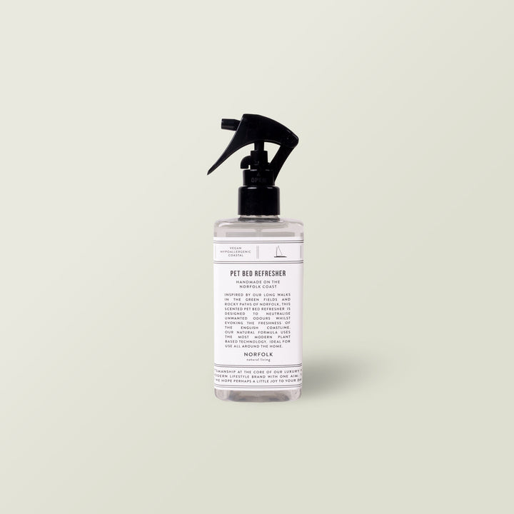 Aromatherapy Dog Bed Refresher Spray in a clear spray bottle with black nozzle on a pale sage background