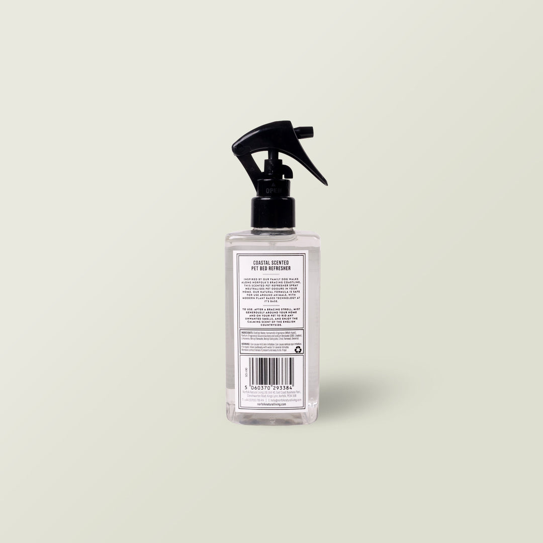 Aromatherapy Dog Bed Refresher Spray in a clear spray bottle with black nozzle on a pale sage background