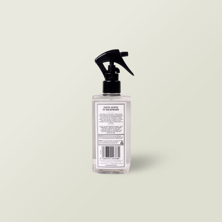 Aromatherapy Dog Bed Refresher Spray in a clear spray bottle with black nozzle on a pale sage background