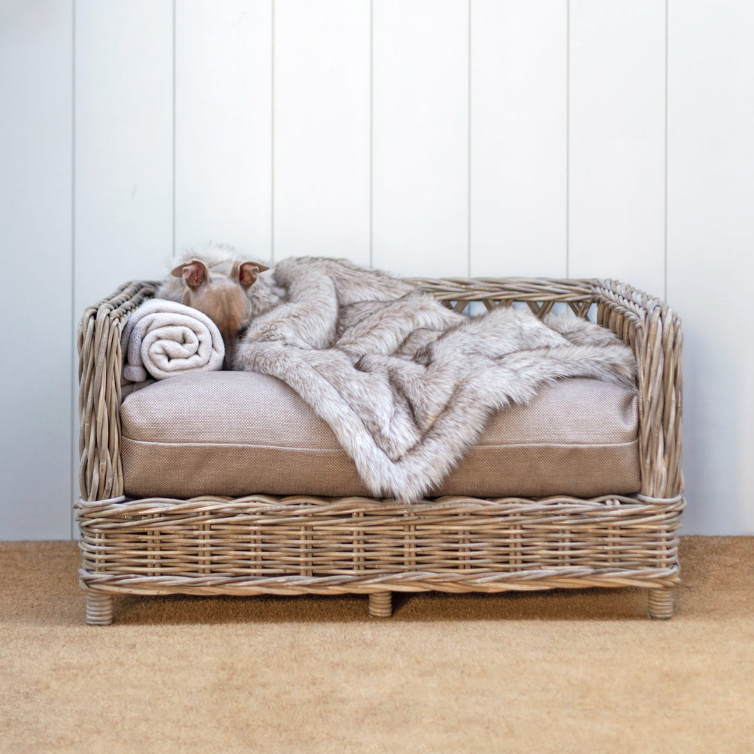 A beautiful wicker dog bed - the Raised Rattan Dog Bed with luxury dog bed mattress and faux-fur dog blanket.