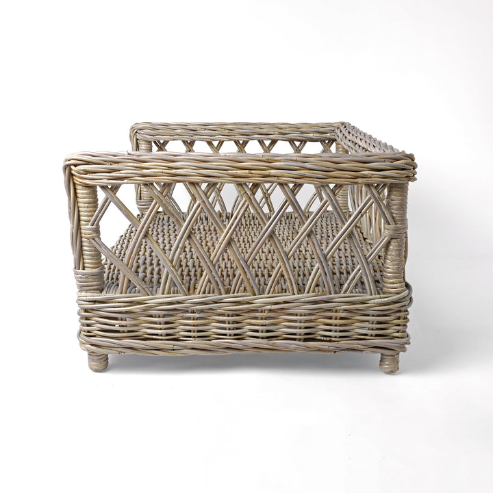 Raised Rattan Dog Bed frame on a white background. A raised dog bed woven with rattan canes to create a lattice style frame.