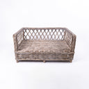 Front view of Charley Chau's Raised Rattan Dog Bed frame, woven with natural rattan canes with a lattice effect, placed on a white background.