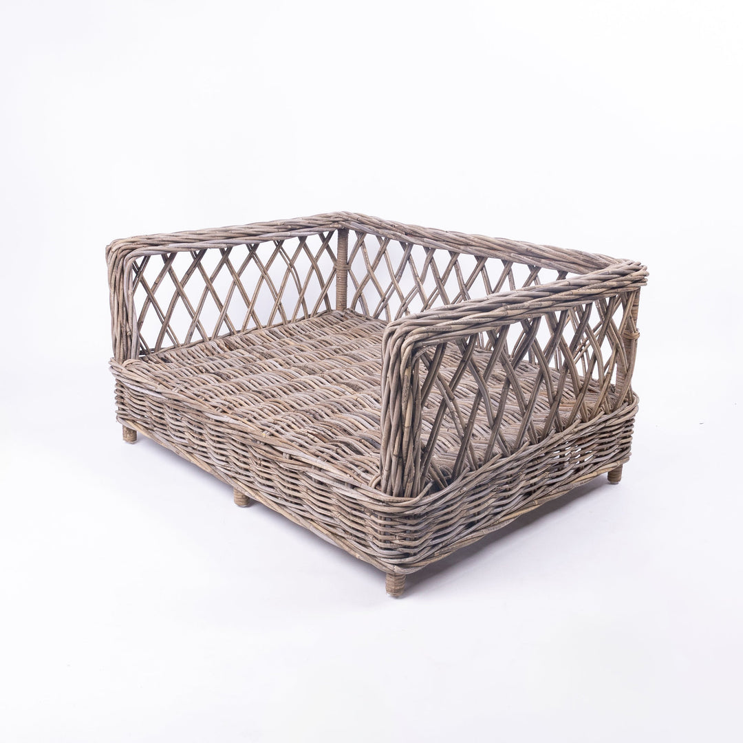 Charley Chau's Raised Rattan Dog Bed frame, woven with natural rattan canes with a lattice effect, placed on a white background.