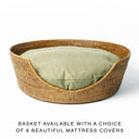 A golden tan colour round Rattan Dog Basket with a fern green dog bed mattress inside with text advising of multiple colour choices available for the dog bed mattress.