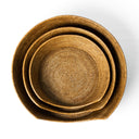 An overhead shot looking down onto three round golden tan coloured rattan peel dog baskets nested together. 
