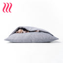 Italian Greyhound dog sleeping in a sleeping bag style luxury dog snuggle bed in a heron grey colour on a white background.