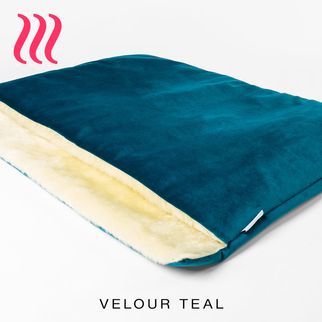Luxury sleeping bag stlye dog bed outer cover in teal colour velvet with a cream faux-fur lining on a white background.