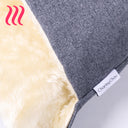 Close up detail of a Charley Chau brand label on a dog bed made from a dark grey fabric with a ceam faux-fur lining.