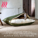 Charley Chau kuxury sleeping bag style dog bed in leaf green velvet with a cream lining in a white interior with hessian floor and an Italian Greyhound peeking out of the bed.