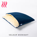 Luxury Dog Snuggle Bed, a sleeping bag style dog bed, with the outer cover in a dark blue velvet and cream faux-fur on the inside of the bed, on a white background.