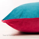 Closeup of a two-toned machine washable velvet dog bed in blue and pink on a white background, Teal & Fuchsia.
