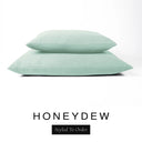 Two luxury dog bed mattresses in a pale sage green upholstery fabric stacked on top of each other, with 'HONEYDEW' and a black 'Styled To Order' label on a white background; these machine washable dog bed mattresses are made for lasting comfort and easy care.