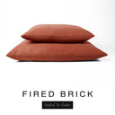 Two luxury dog bed mattresses in a warm terracotta orange-red upholstery fabric stacked on top of each other, with 'FIRED BRICK' and a black 'Styled To Order' label on a white background; these machine washable dog bed mattresses are made for lasting comfort and easy care.