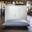 Grey luxury dog bed mattress  in a home setting with a wooden floor. 