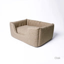 Beige high-sided luxury dog bed made with a textured woven upholstery fabric on a white backdrop.