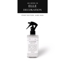 A bottle of pet bed anti-bacterial and anti-odour pet bed refresher on a pale sage backgrund on a white background with a press feature badge "As seen in Elle Decoration".