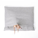 Seen from above, Italian Greyhound Dog peeping out of luxury dog burrow bag, a snuggle sack style dog bed with a built in cover, in a woven grey upholstery fabric on a white background