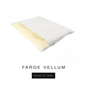 A luxurious Dog Burrow Bag, a sleeping bag style dog bed or snuggle sack style dog bed, with an outer cover in pale cream woven wool texture upholstery fabric Faroe with a plush, cream faux-fur lining, and a badge with the colour name Vellum on a white background.