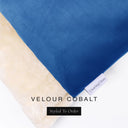 A close up detail of the corner of a Charley Chau Burrow Bag Dog Bed with bright cobalt blue outer cover in upholstery-quality Velour and plush cream faux-fur lining with a woven brand label showing the Charley Chau logo on a white backdrop.