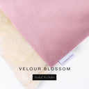 A close up detail of the corner of a Charley Chau Burrow Bag Dog Bed with pink outer cover in upholstery-quality Velour and plush cream faux-fur lining with a woven brand label showing the Charley Chau logo on a white backdrop.