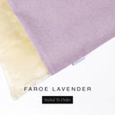 A close up detail of the corner of a Charley Chau Burrow Bag Dog Bed with pale lilac outer cover in woven wool texture upholstery fabric Faroe and plush cream faux-fur lining with a woven brand label showing the Charley Chau logo on a white backdrop.