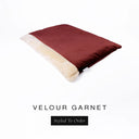 A luxurious Dog Burrow Bag, a sleeping bag style dog bed or snuggle sack style dog bed, with an outer cover in deep burgundy red upholstery-quality Velour with a plush, cream faux-fur lining, and a badge with the colour name Garnet on a white background.