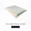 A luxurious Dog Burrow Bag, a sleeping bag style dog bed or snuggle sack style dog bed, with an outer cover in pale sage green upholstery-quality Velour with a plush, cream faux-fur lining, and a badge with the colour name Pale Sage on a white background.