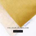 A close up detail of the corner of a Charley Chau Burrow Bag Dog Bed with golden yellow outer cover in upholstery-quality Velour and plush cream faux-fur lining with a woven brand label showing the Charley Chau logo on a white backdrop.