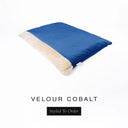 A luxurious Dog Burrow Bag, a sleeping bag style dog bed or snuggle sack style dog bed, with an outer cover in bright cobalt blue upholstery-quality Velour with a plush, cream faux-fur lining, and a badge with the colour name Cobalt on a white background.