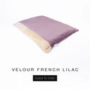 A luxurious Dog Burrow Bag, a sleeping bag style dog bed or snuggle sack style dog bed, with an outer cover in mid purple upholstery-quality Velour with a plush, cream faux-fur lining, and a badge with the colour name French Lilac on a white background.