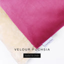 A close up detail of the corner of a Charley Chau Burrow Bag Dog Bed with bright fuchsia pink outer cover in upholstery-quality Velour and plush cream faux-fur lining with a woven brand label showing the Charley Chau logo on a white backdrop.