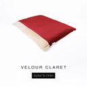 A luxurious Dog Burrow Bag, a sleeping bag style dog bed or snuggle sack style dog bed, with an outer cover in red upholstery-quality Velour with a plush, cream faux-fur lining, and a badge with the colour name Claret on a white background.
