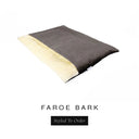 A luxurious Dog Burrow Bag, a sleeping bag style dog bed or snuggle sack style dog bed, with an outer cover in dark brown woven wool texture upholstery fabric Faroe with a plush, cream faux-fur lining, and a badge with the colour name Bark on a white background.