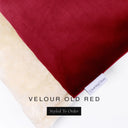 A close up detail of the corner of a Charley Chau Burrow Bag Dog Bed with brick red outer cover in upholstery-quality Velour and plush cream faux-fur lining with a woven brand label showing the Charley Chau logo on a white backdrop.