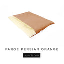 A luxurious Dog Burrow Bag, a sleeping bag style dog bed or snuggle sack style dog bed, with an outer cover in terracotta orange woven wool texture upholstery fabric Faroe with a plush, cream faux-fur lining, and a badge with the colour name Persian Orange on a white background.