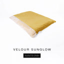 A luxurious Dog Burrow Bag, a sleeping bag style dog bed or snuggle sack style dog bed, with an outer cover in golden yellow upholstery-quality Velour with a plush, cream faux-fur lining, and a badge with the colour name Sunglow on a white background.