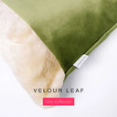 A close up detail of the corner of a Charley Chau Dog Snuggle Bed with olive green outer cover in upholstery-quality Velour and plush cream faux-fur lining with a woven brand label showing the Charley Chau logo on a white backdrop.