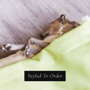 Dog sleeping cosy with head sticking out of a dog snuggle bed with a lime green velvet outer cover and plush creamlining on the inside with 'Styled To Order' text overlay.