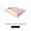 A Charley Chau Snuggle Bed, a cave bed or sleeping bag style dog bed made with a pink woven upholstery-quality fabric with cream, plush, faux-fur lining on a white backdrop.
